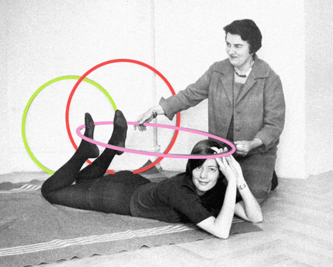 A woman lying on her belly. An older woman holding a Hula-Hoop over her back.