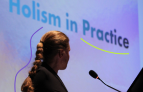 A woman doing a presentation in front of a screen