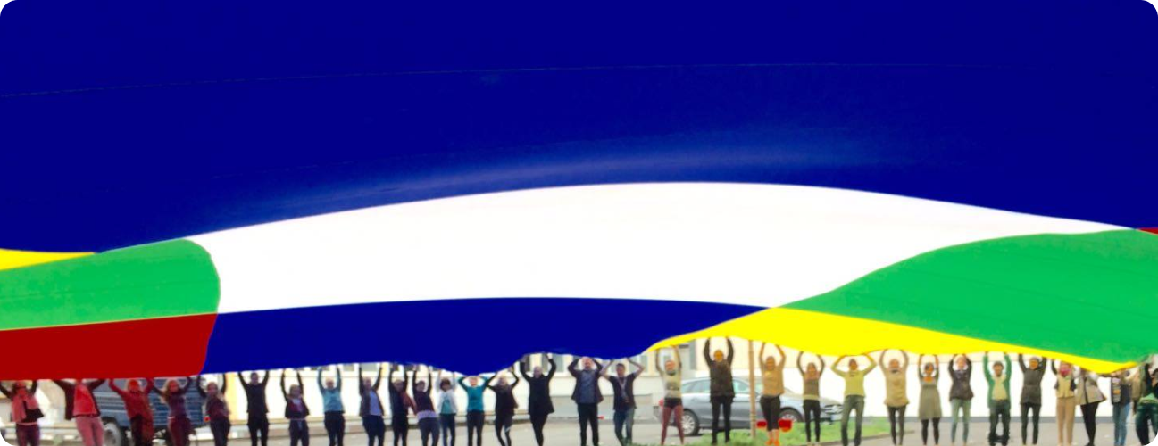 A group of people standing in a circle, holding a large colorful parachute.