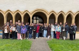 Group of people with an antic building behing